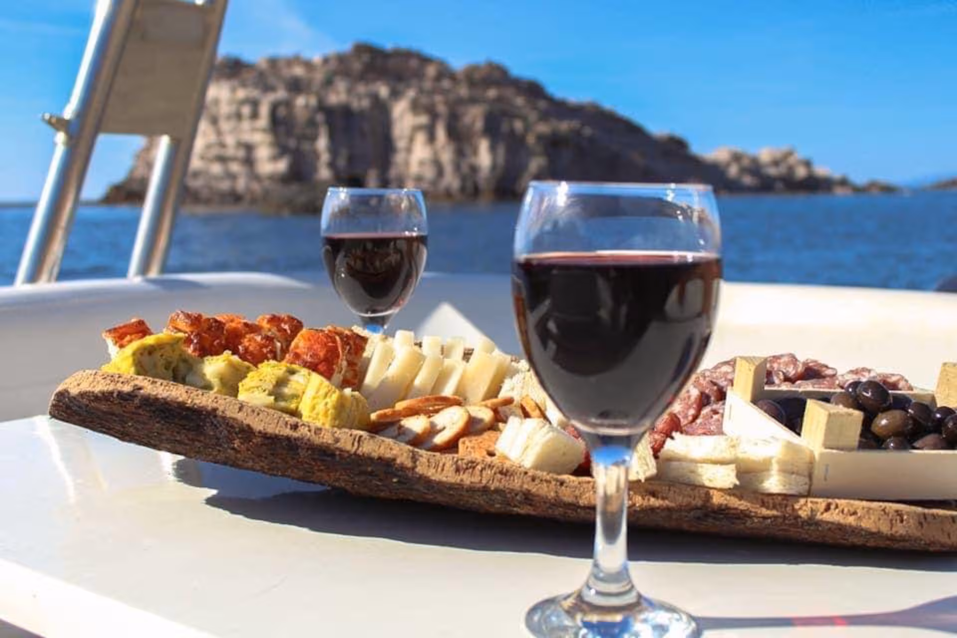 Wine glasses and a charcuterie board on a RIB tour with stunning views between Carloforte and Masua.