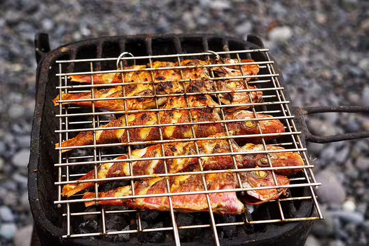 Fresh fish grilling on beach BBQ, part of Ribeira da Barca boat trip with cave visit and snorkeling in Cape Verde
