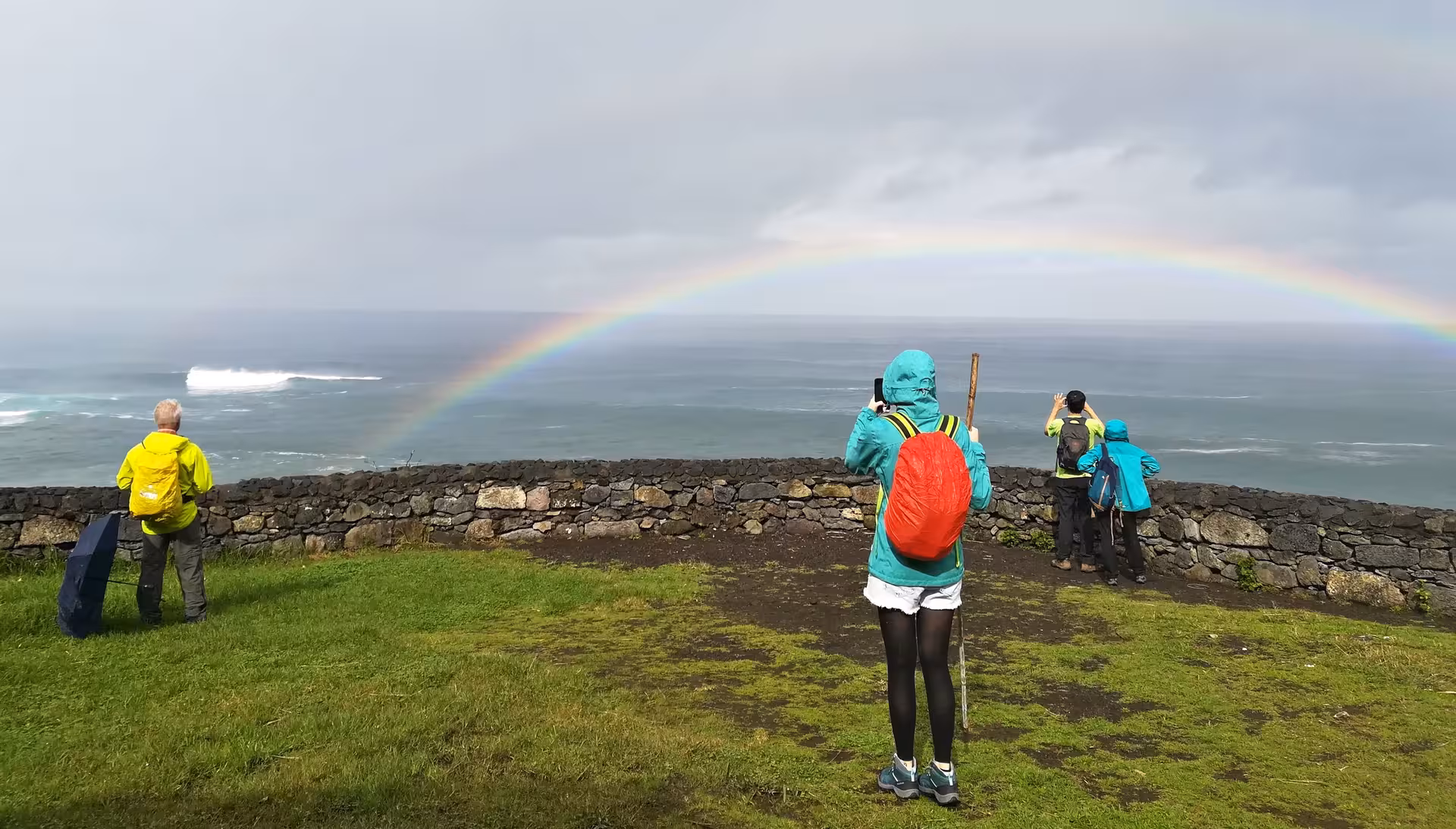 Hikers viewing ocean rainbow from cliff lookout on Ribeira Funda and Praia da Viola full-day walking tour