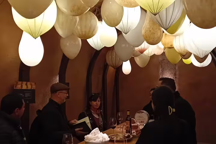 Visitors enjoy a wine tasting under unique lighting at a Ribera del Duero winery tour from Madrid.
