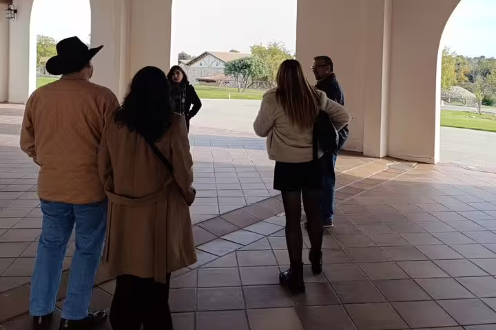 Visitors gather under an archway at a Ribera del Duero winery, part of a guided tour from Madrid.