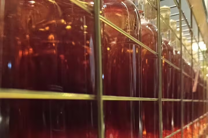 Close-up of wine bottles stored in a winery in Ribera del Duero, showcasing rich red hues.