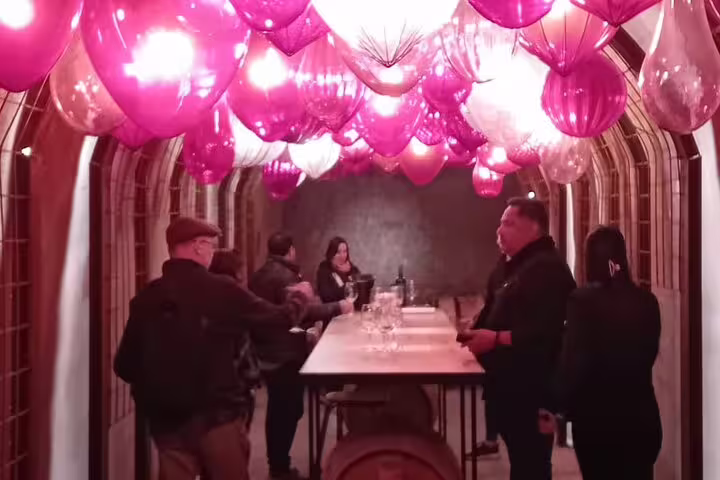 Guests gather under vibrant balloon decor in a Ribera del Duero winery tasting room, enhancing the festive atmosphere.