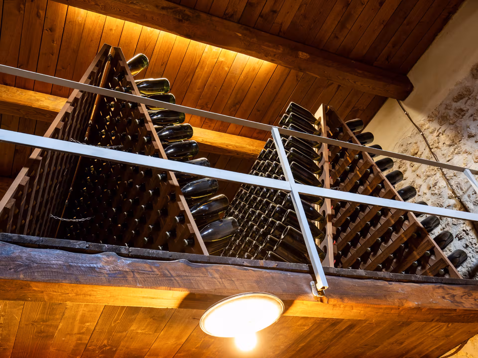 View of wine bottles stacked in a rustic Rieti winery cellar, showcasing traditional aging processes.