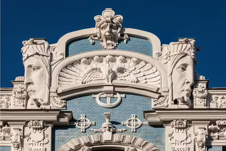 Art Nouveau building facade in Riga with ornate sculptural faces and decorative relief carvings