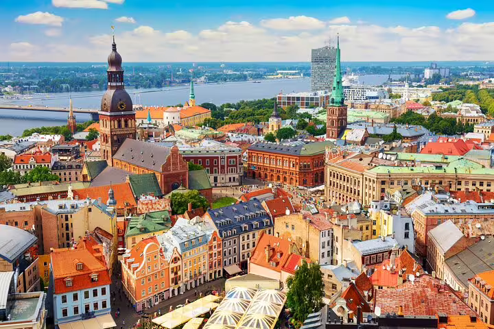 Aerial view of Riga Old Town with colorful rooftops, cathedral spire, and Daugava River in background