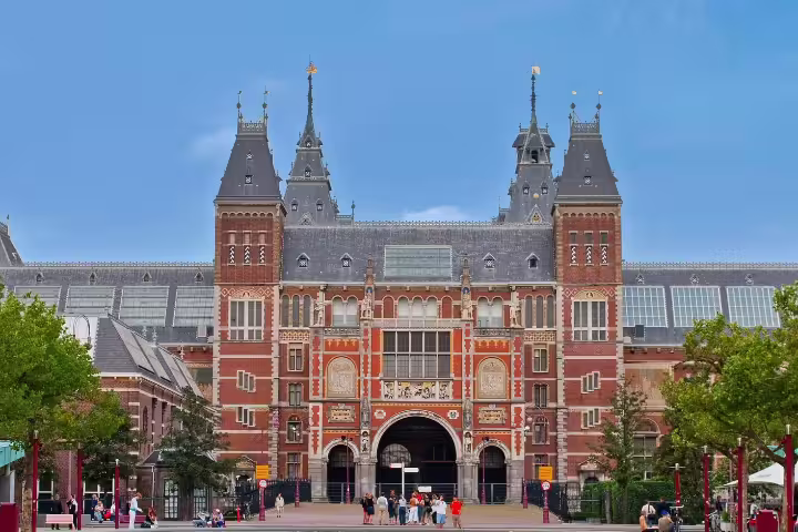 Exterior view of the iconic Rijksmuseum in Amsterdam, showcasing its stunning architecture on a clear day, perfect for a guided tour.