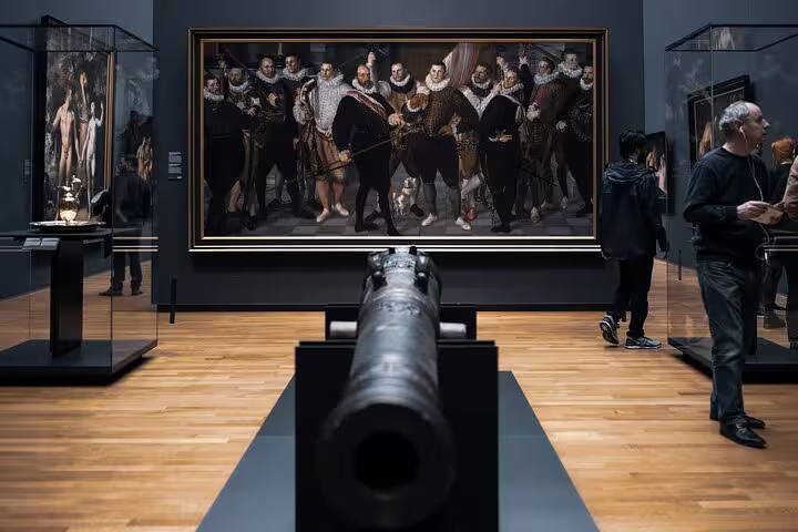 Rijksmuseum gallery with Dutch Golden Age group portrait and historic cannon on guided museum tour