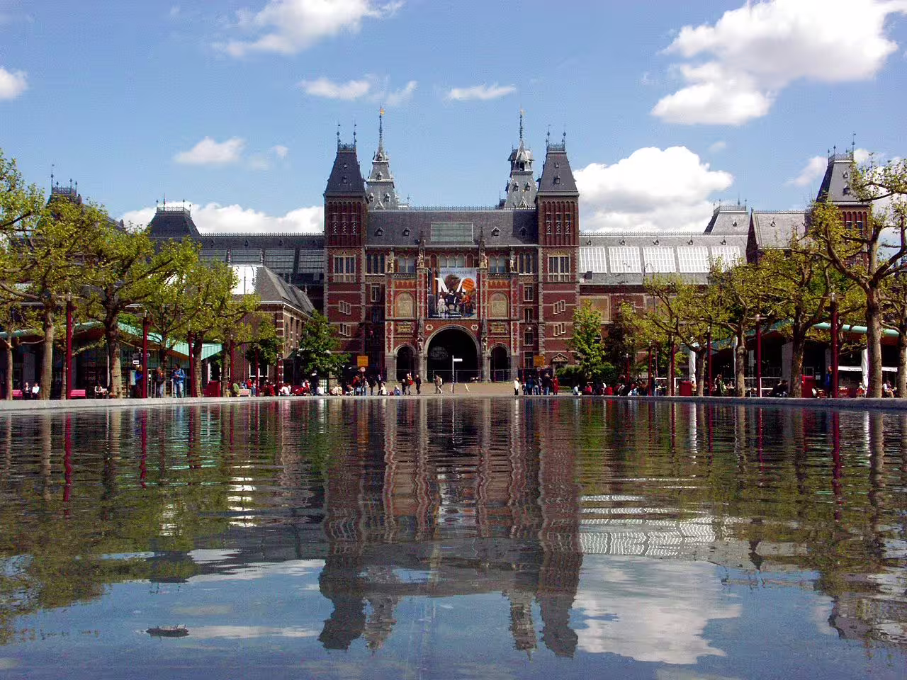 Scenic view of the Rijksmuseum façade with reflecting pool, perfect for a guided tour exploring Amsterdam's art and history treasures.