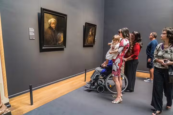 Guests view Rembrandt paintings in the Rijksmuseum on a guided Stories Behind the Masterpieces tour