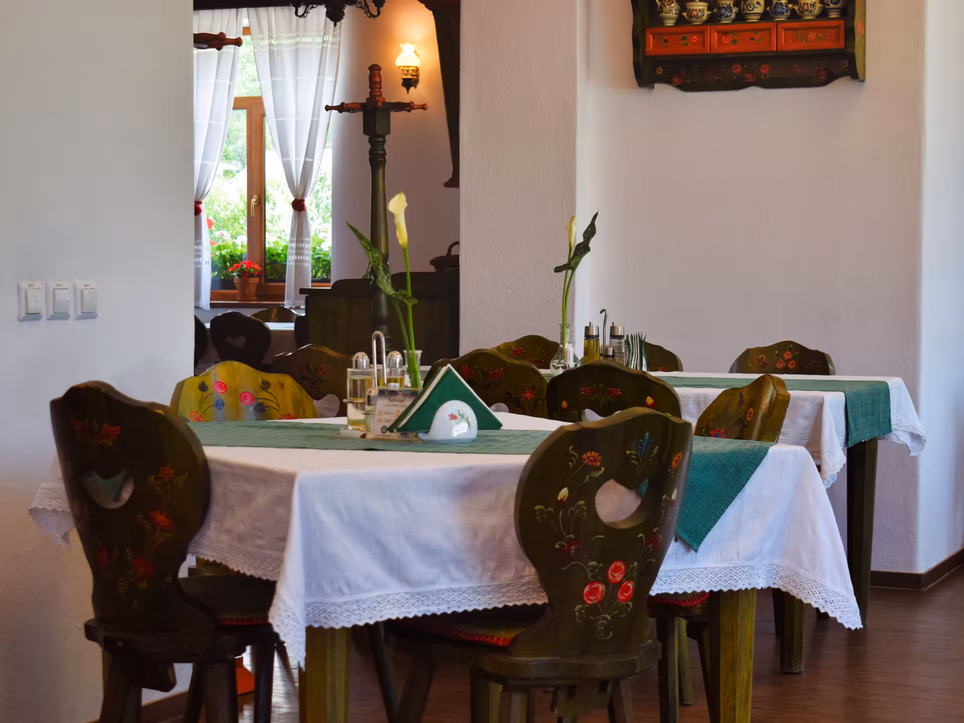 Charming folk-decorated dining room with hand-painted chairs for a guided dinner tour in Rimetea village Romania