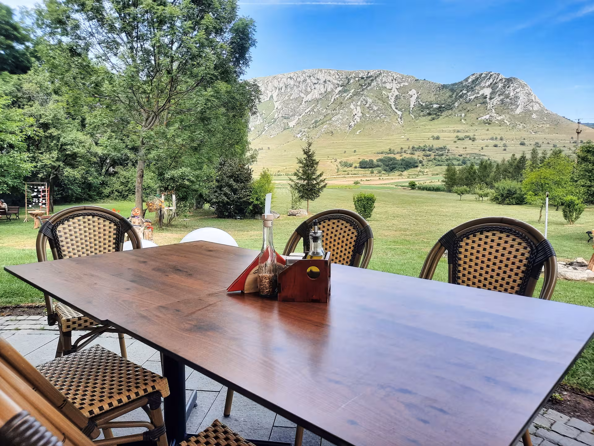 Outdoor dining table with scenic Apuseni Mountains backdrop perfect for a guided dinner tour experience in Rimetea Romania