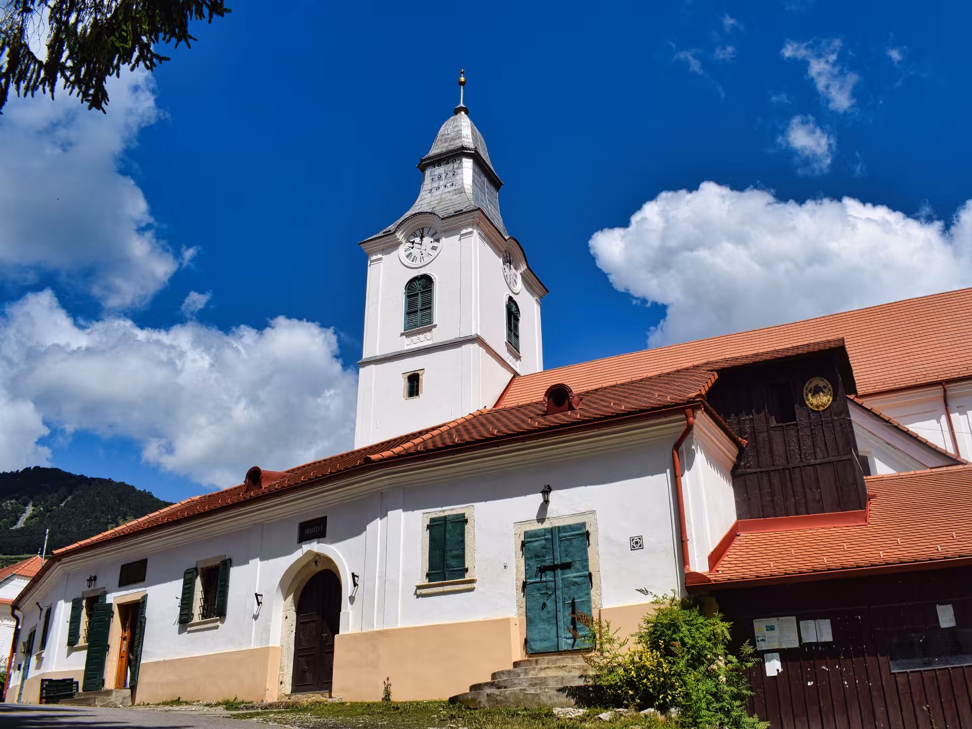 Historic white church with clock tower in Rimetea village, a cultural highlight of the Apuseni Mountains dinner tour