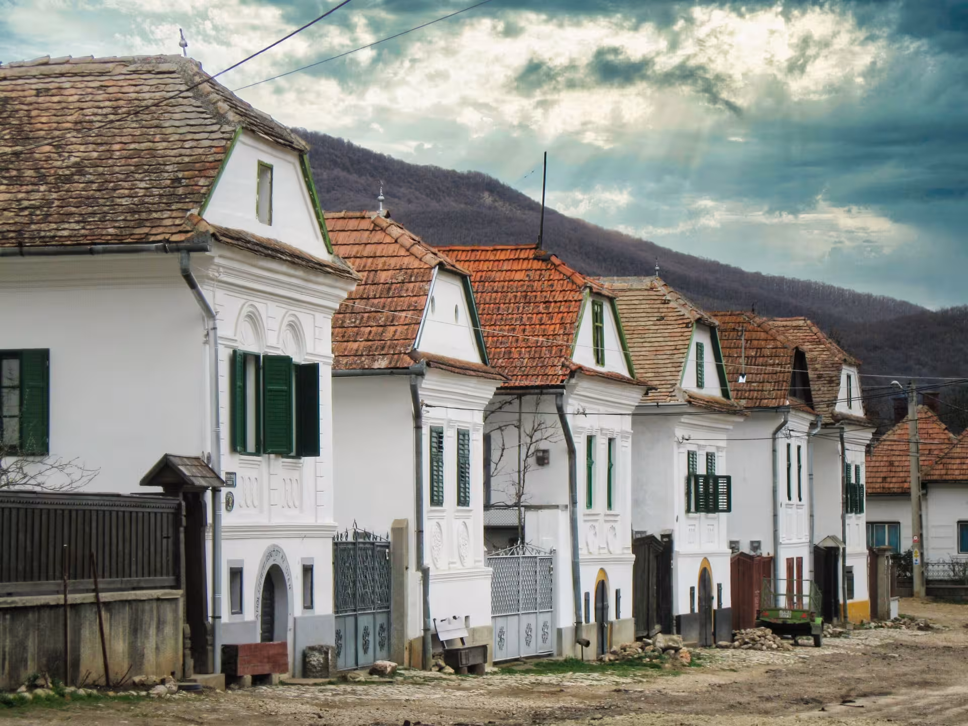 Charming traditional white houses with red tile roofs lining a historic street in Rimetea village, Apuseni Mountains Romania