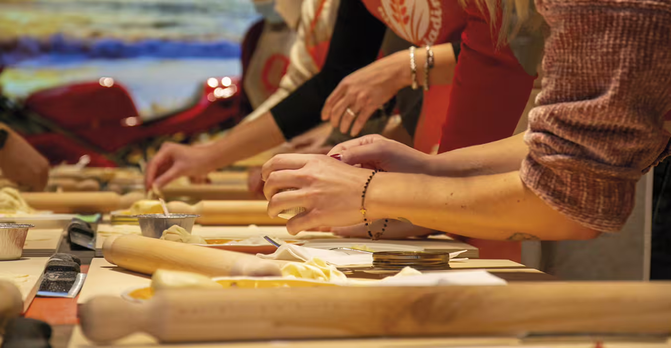 Hands shaping dough with rolling pins at Rimini Piadina Museum, Italy food tour with lunch or dinner tasting