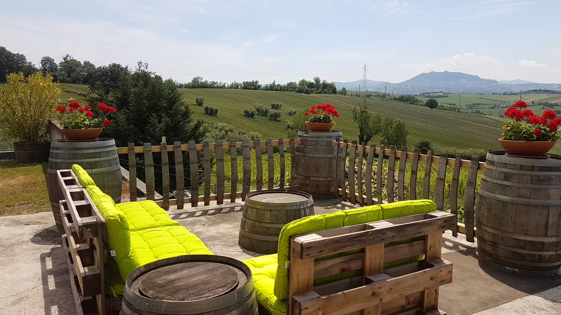 Scenic terrace with barrel furniture overlooking Rimini vineyards, perfect for San Valentino wine tasting.