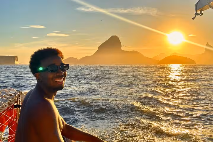 Guest enjoying sunset sail past Sugarloaf on Rio catamaran, private 5-hour tour with BBQ and open bar