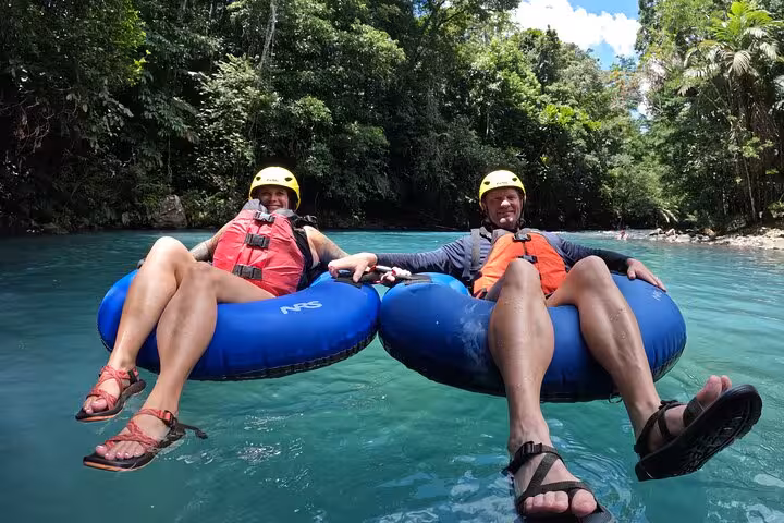 Adventurers enjoy tubing on the turquoise waters of Rio Celeste during a full-day hiking and tubing tour in Costa Rica.