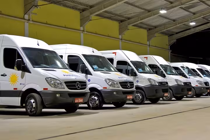 Fleet of private shuttle vans ready for Rio de Janeiro to Buzios transfer service, parked in a spacious garage.