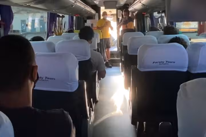 Interior of a Paraty Tours shuttle bus with seated passengers heading to Ilha Grande from Rio de Janeiro.