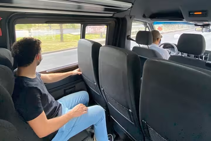 Passenger enjoying comfortable shuttle ride from Rio to Ilha Grande, showcasing spacious interior and scenic views.