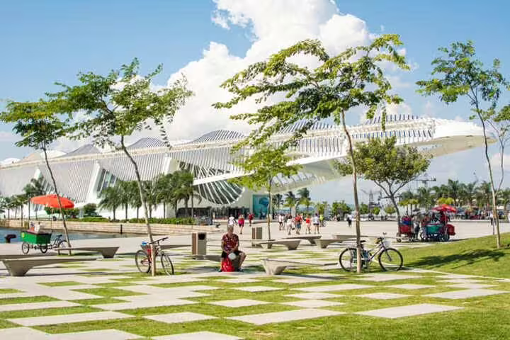Tourists explore Rio's futuristic Museum of Tomorrow, a highlight of the downtown walking tour with lush surroundings.