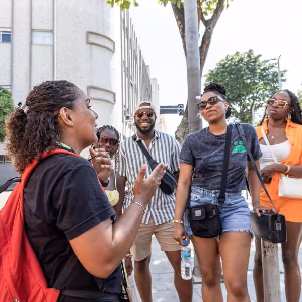 A guide engaging tourists during the Rio's Historic Center & Little Africa Walking Tour, sharing cultural insights.