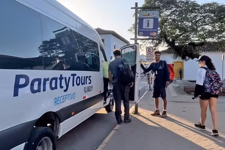 Passengers entering a Paraty Tours shuttle, ready for a shared journey from Rio de Janeiro to Angra dos Reis.