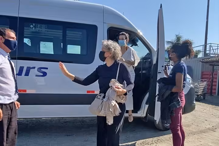 Travelers with masks boarding a shuttle for a Rio de Janeiro to Ilha Grande transfer, ensuring a safe journey.