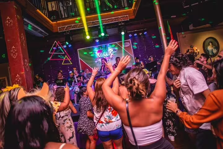 Joyful crowd dancing to live music under colorful lights in a bustling Rio nightclub, showcasing the city's energetic nightlife.