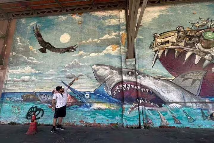 Dramatic ocean-themed mural with sharks in Rio, showcasing urban art on the Graffiti Tour.