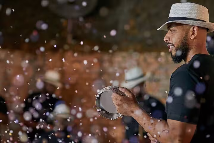Musician playing a tambourine amidst festive confetti during a Rio nightlife samba tour.