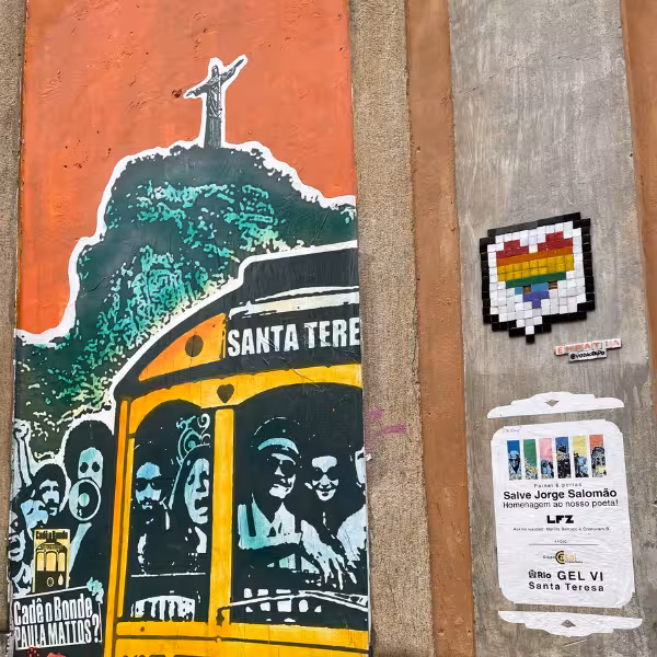 Vibrant street art in Santa Teresa featuring colorful tram and Christ the Redeemer, highlighting Rio's cultural vibe.