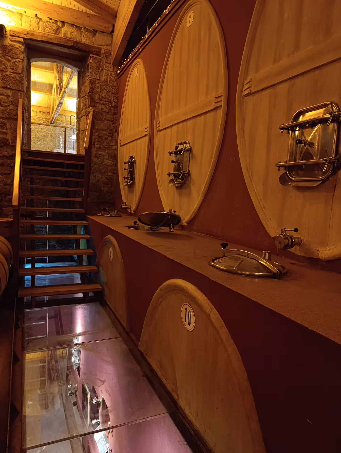 Tour a rustic Rioja wine cellar featuring large oak barrels, showcasing traditional wine aging techniques.