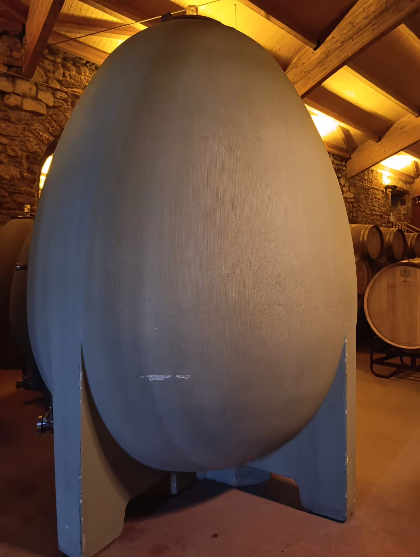 Close-up of a large concrete egg-shaped fermentation tank inside a Rioja winery.