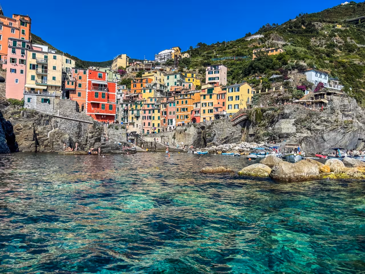 Riomaggiore Cinque Terre seen from the sea on a La Spezia full-day boat tour, colorful cliffs and clear water