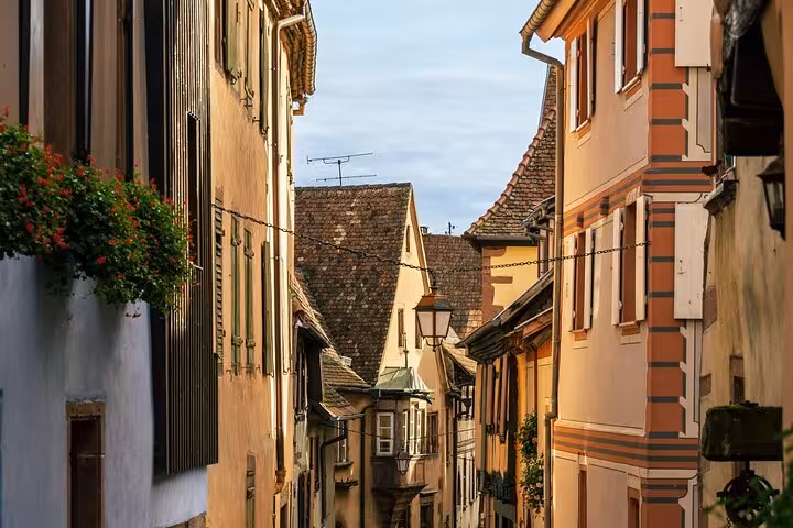 Narrow cobblestone street lined with colorful half-timbered buildings in Riquewihr, Alsace, France