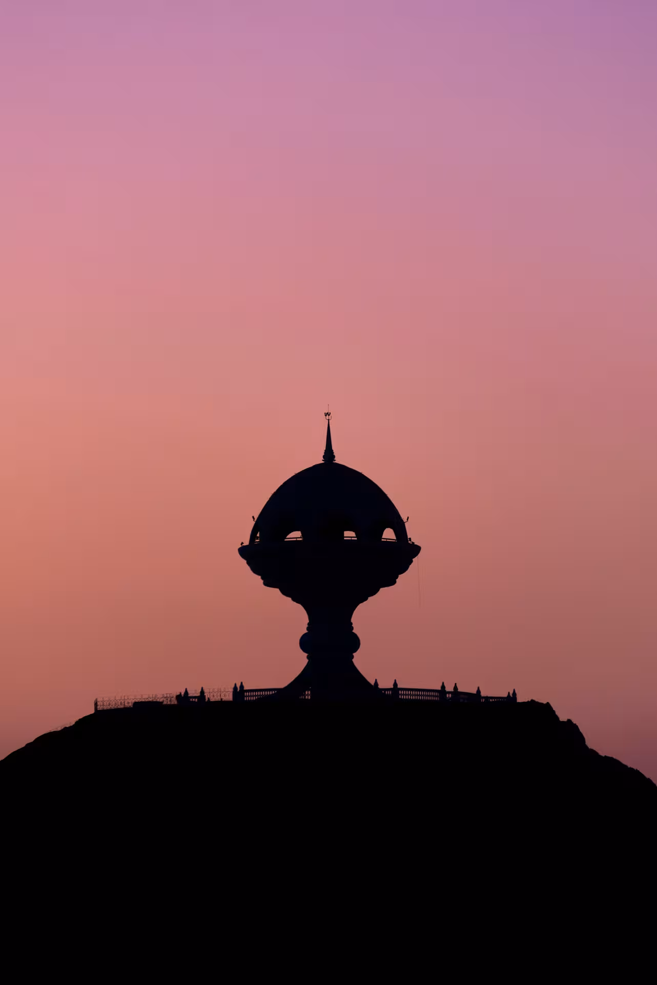 Silhouette of Riyam Monument at sunset, a popular Muscat sightseeing stop on private chauffeur-driven city tours