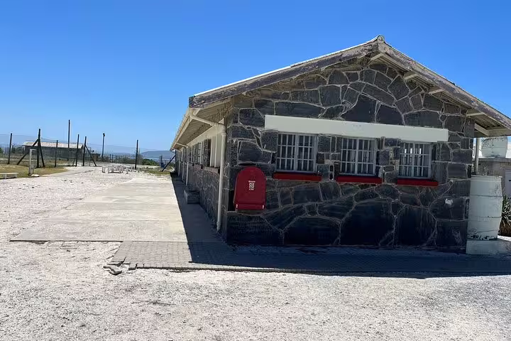 Historic building on Robben Island under blue skies, part of the guided museum tour experience.