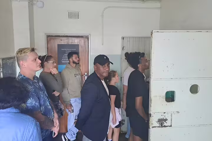 Visitors explore a historic cell on the Discover Robben Island guided museum tour, highlighting its rich cultural history.