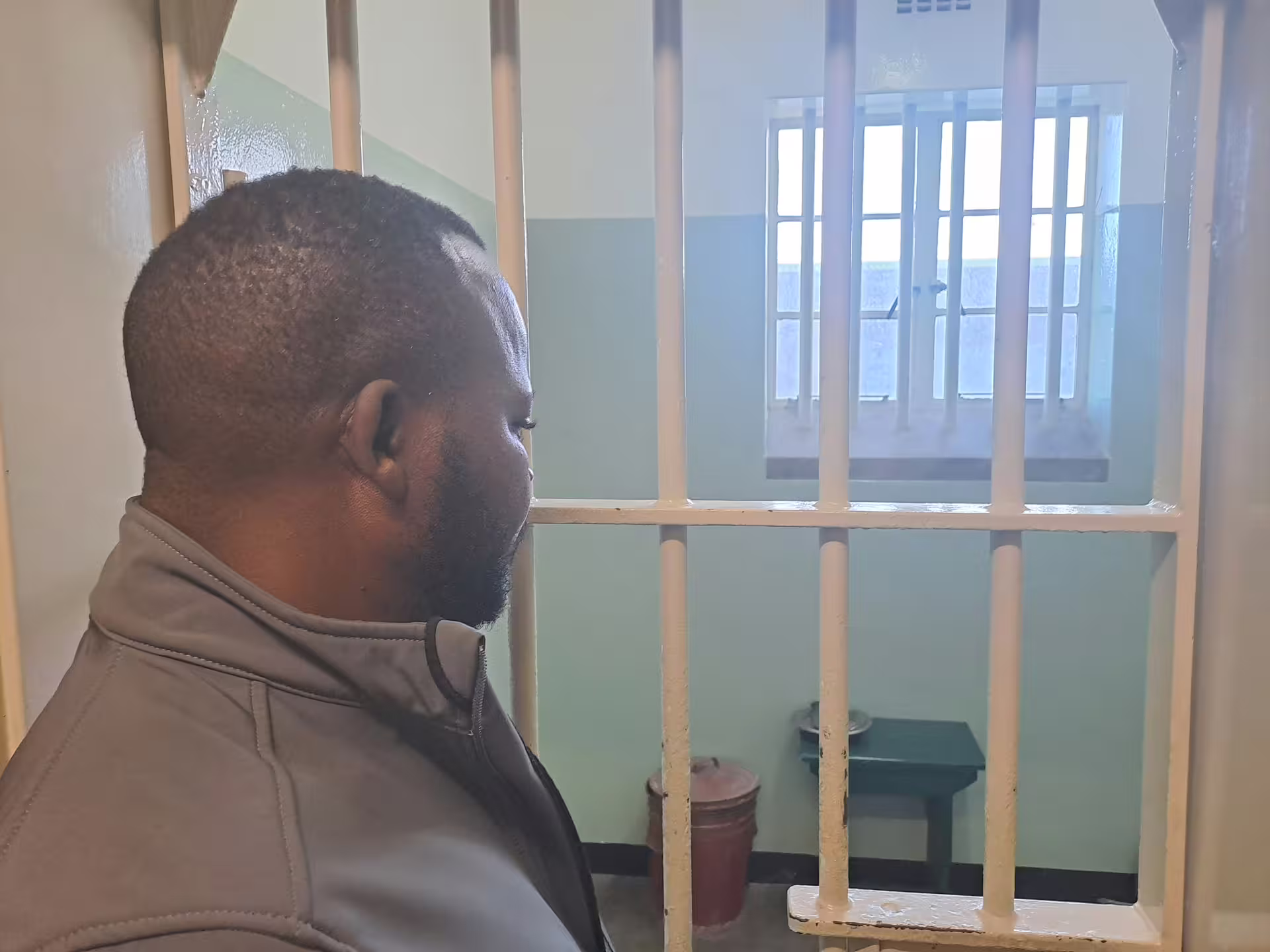 Visitor exploring a historic cell at Robben Island Museum, a key site on Cape Town's cultural heritage tour.