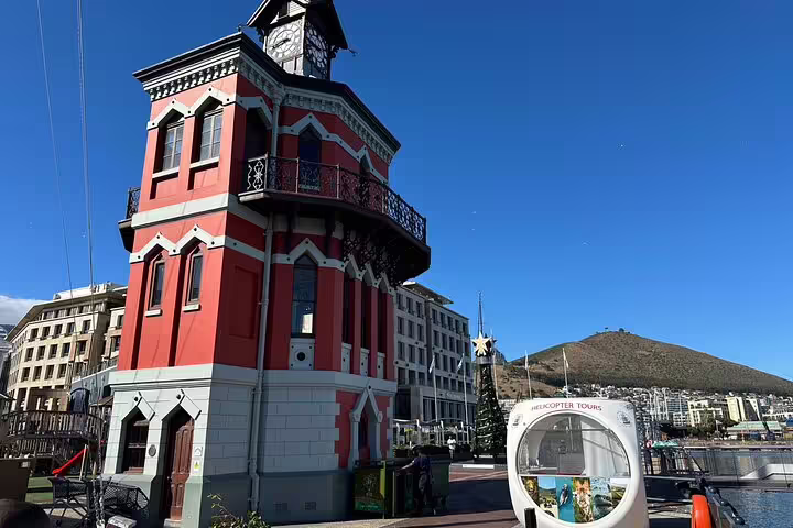 Scenic view of a historic building near Robben Island ferry departure, with Table Mountain in the background.