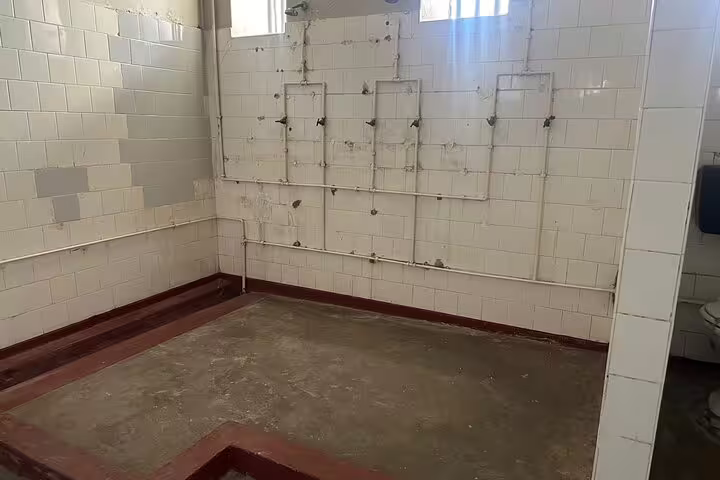 Robben Island prison shower area showcasing the historic conditions of the facility.