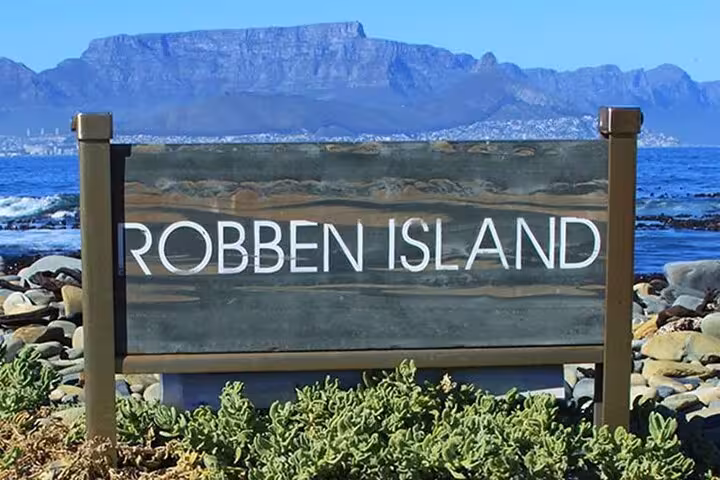 Robben Island sign with scenic backdrop of Table Mountain, a highlight of the half-day tour experience.