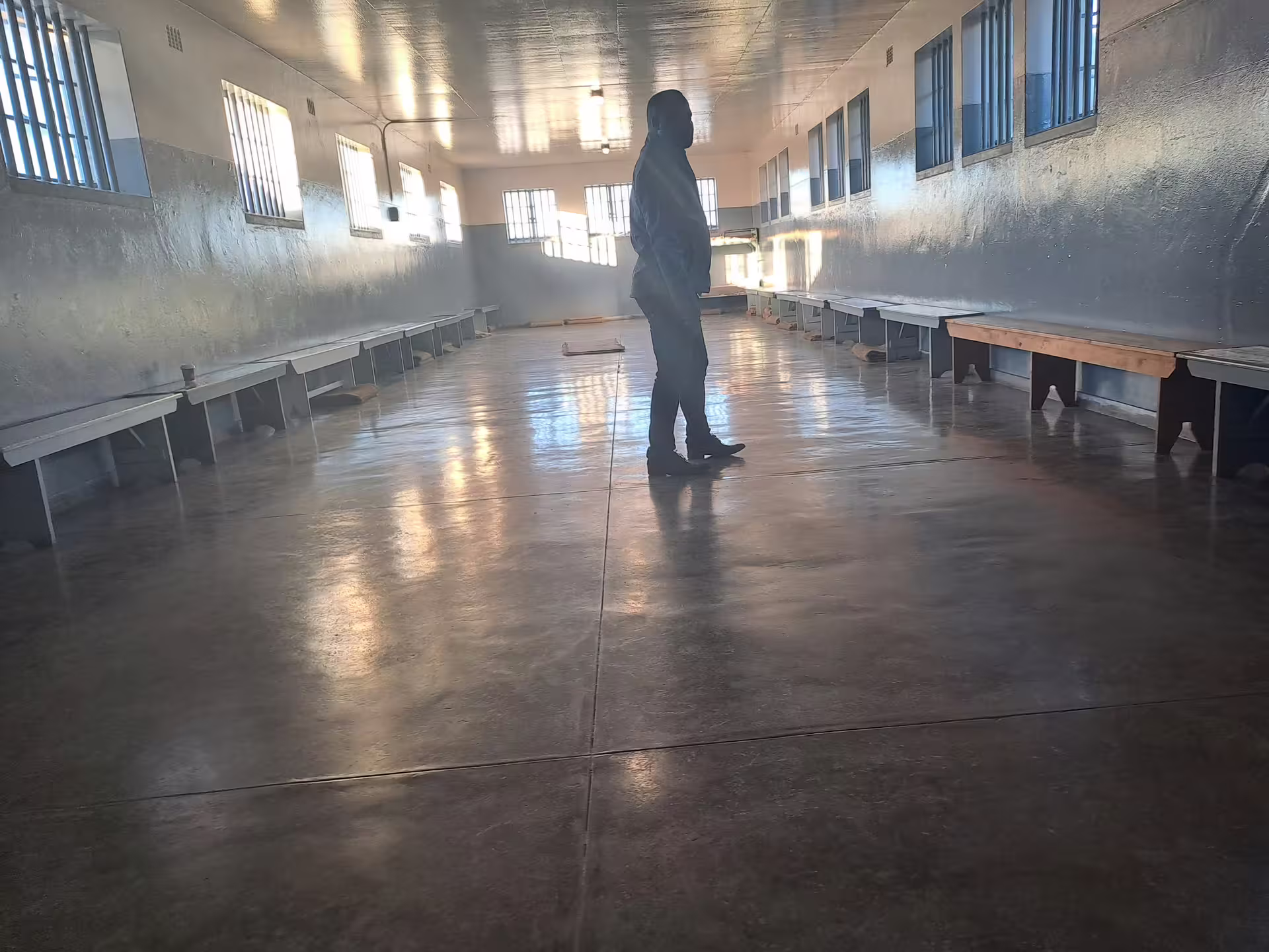 Guide standing in a spacious hall at Robben Island Museum, highlighting the ferry tour's educational aspect.