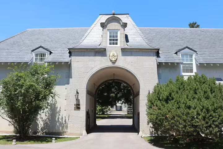 Historic stone gatehouse with arched entrance and slate roof in Rockcliffe Park, Ottawa