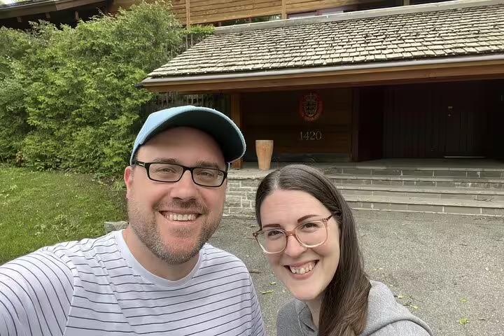 Couple smiling in selfie in front of wooden building 1420 in Rockcliffe Park Ottawa
