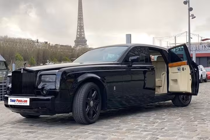 Black Rolls Royce Phantom with open door parked near Eiffel Tower in Paris