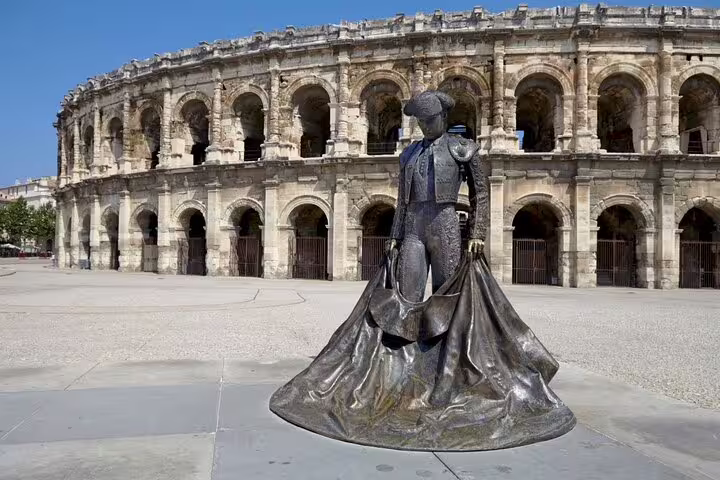Bronze matador statue in front of the ancient Roman arena of Nîmes, France