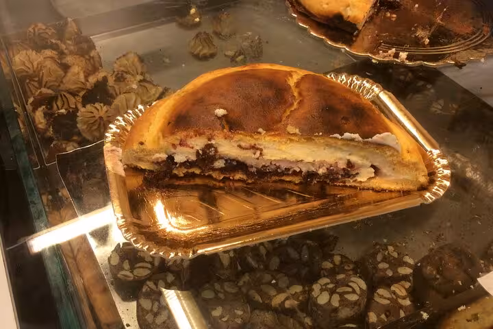 Traditional Roman-Jewish cheesecake displayed in a bakery, showcasing the unique flavors of local cuisine.